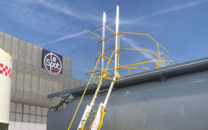 Mobile Sicherheitsleiter des Herstellers Triax steht neben einem Lastwagen, um den lateralen Aufstieg des Containers zu ermöglichen.