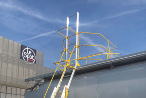 Mobile Sicherheitsleiter des Herstellers Triax steht neben einem Lastwagen, um den lateralen Aufstieg des Containers zu ermöglichen.