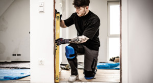 Kniender Handwerker bei der Arbeit mit Knieschonern.