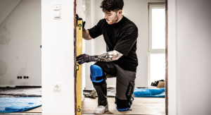Kniender Handwerker bei der Arbeit mit Knieschonern.