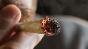 Ein Mann wie er an einem Joint zieht.