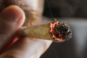 Ein Mann wie er an einem Joint zieht.