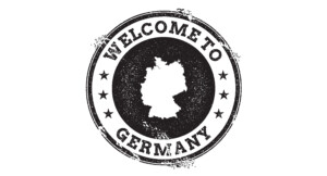 Schwarz-weißer Stempel im Grunge-Look mit der Silhouette Deutschlands in der Mitte und dem Text „WELCOME TO GERMANY“, umgeben von Sternen.